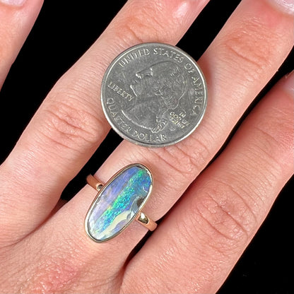 Ladies' yellow gold solitaire ring bezel set with a natural green striped boulder opal from Quilpie, Australia.