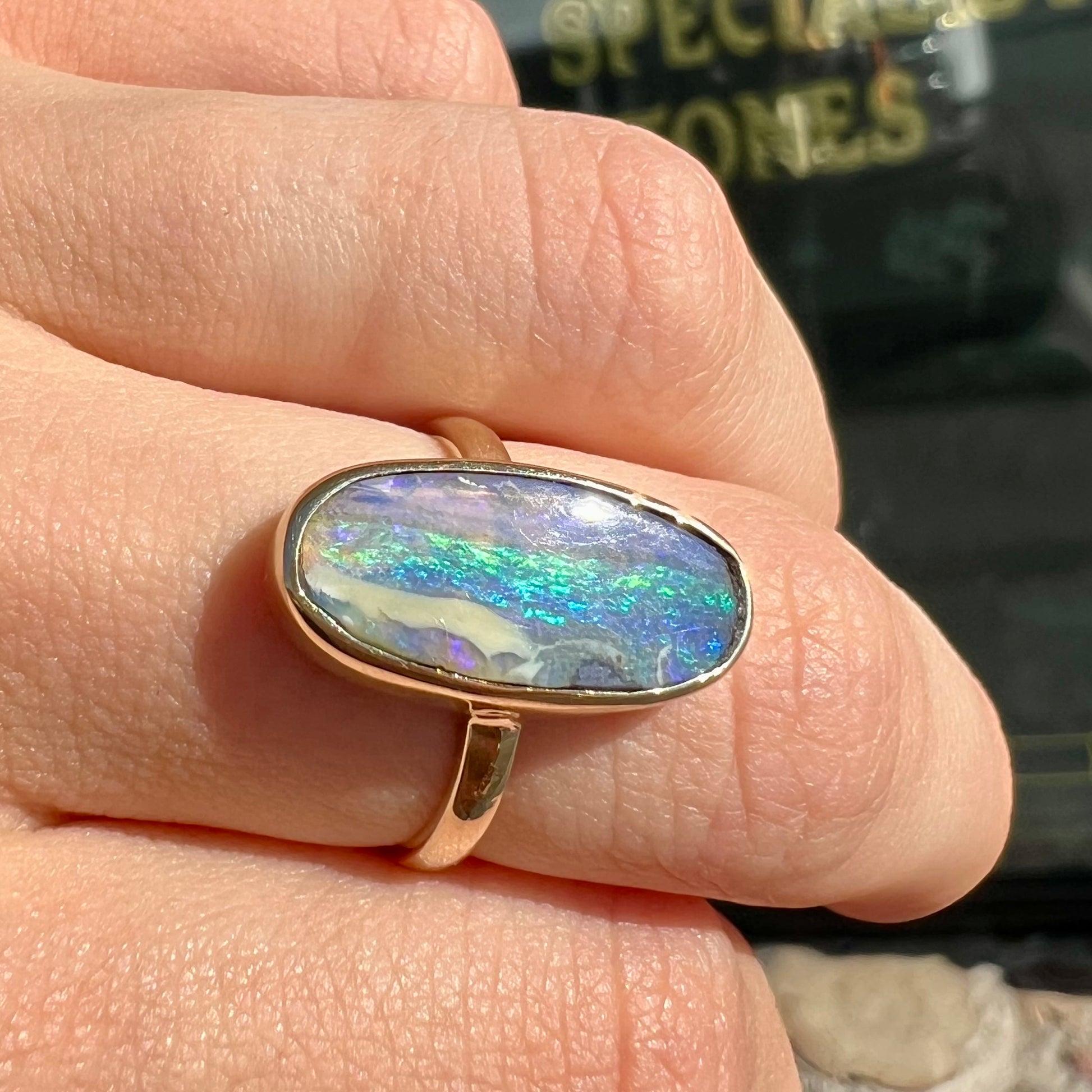 Ladies' yellow gold solitaire ring bezel set with a natural green striped boulder opal from Quilpie, Australia.