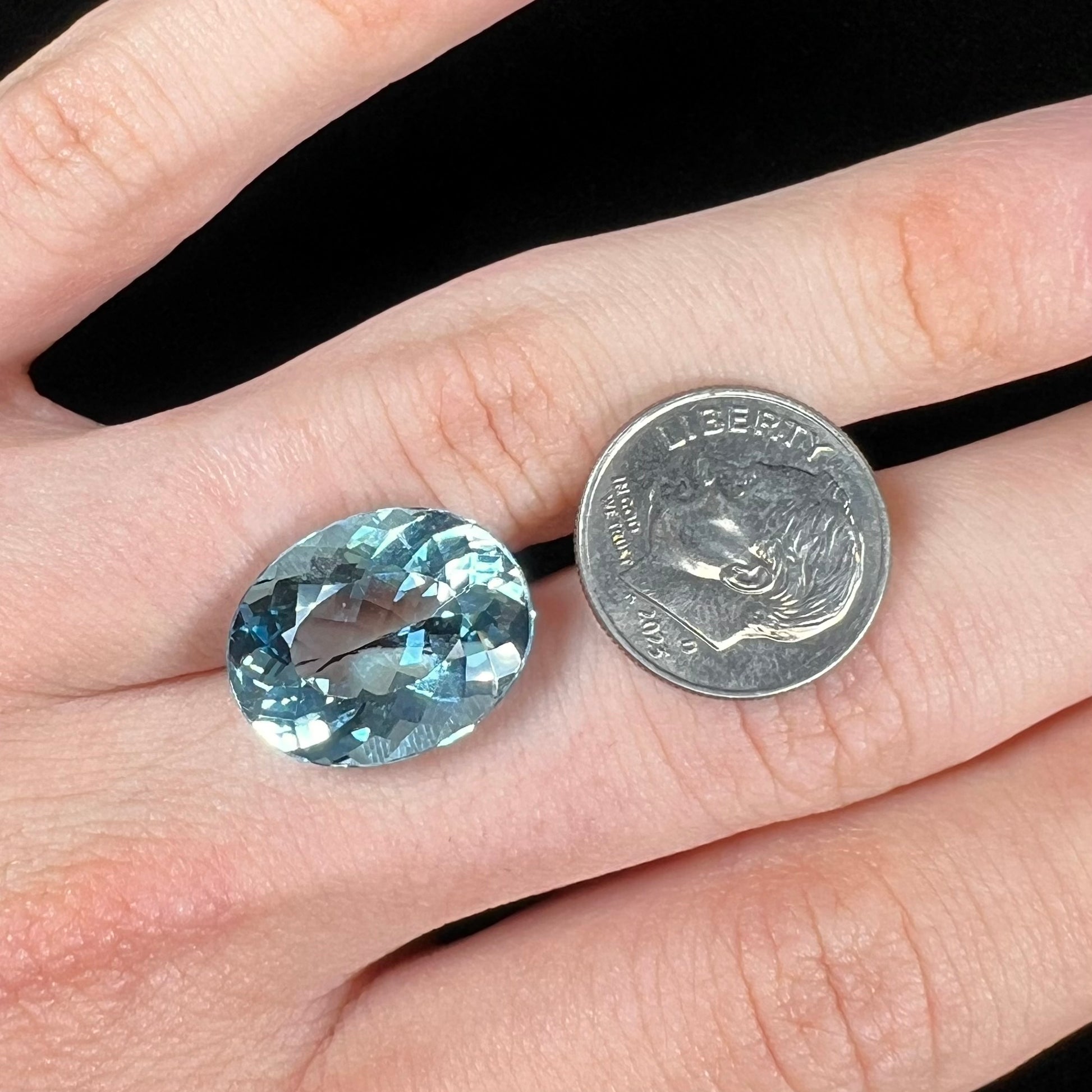 A loose, oval cut Brazilian aquamarine gemstone.  The stone is a rich aqua blue color.