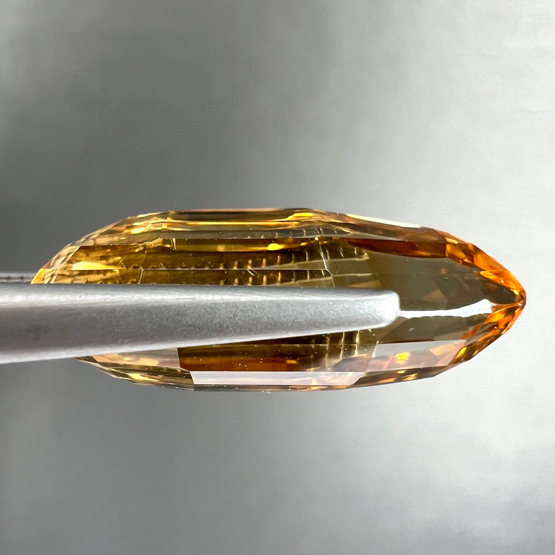 A loose, faceted briolette cut citrine gemstone.