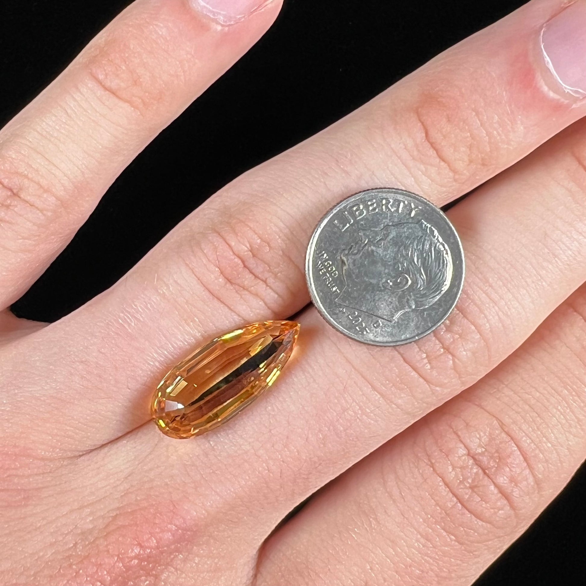 A loose, faceted briolette cut citrine gemstone.