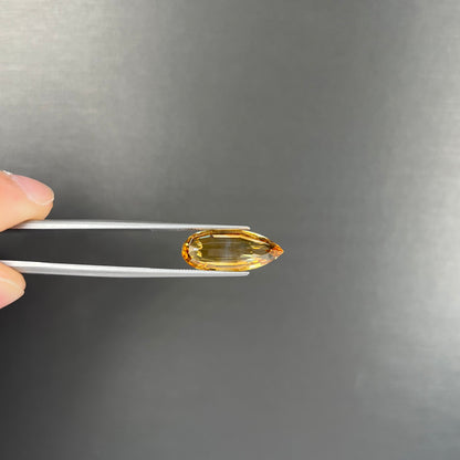 A loose, faceted briolette cut citrine gemstone.