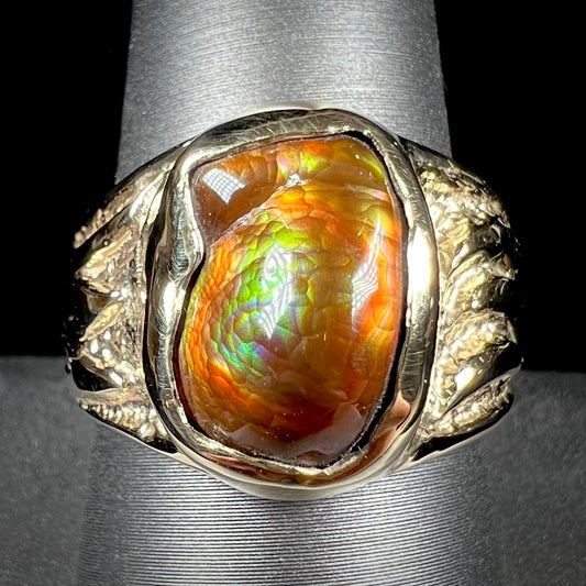 A man's yellow gold solitaire ring set with a freeform shaped Mexican fire agate stone.  The stone has a purple bull's eye pattern.
