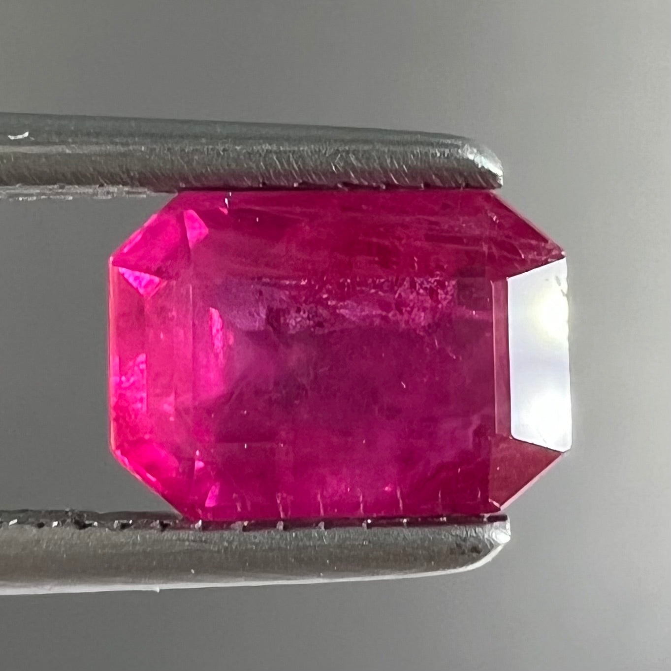 A natural, emerald cut Burma ruby with a purplish pinkish red color.