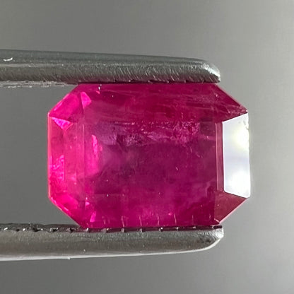 A natural, emerald cut Burma ruby with a purplish pinkish red color.