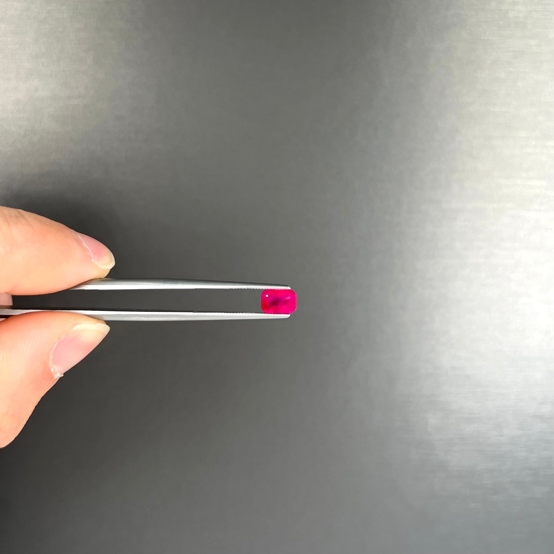 A natural, emerald cut Burma ruby gemstone.  The stone is pinkish red color.