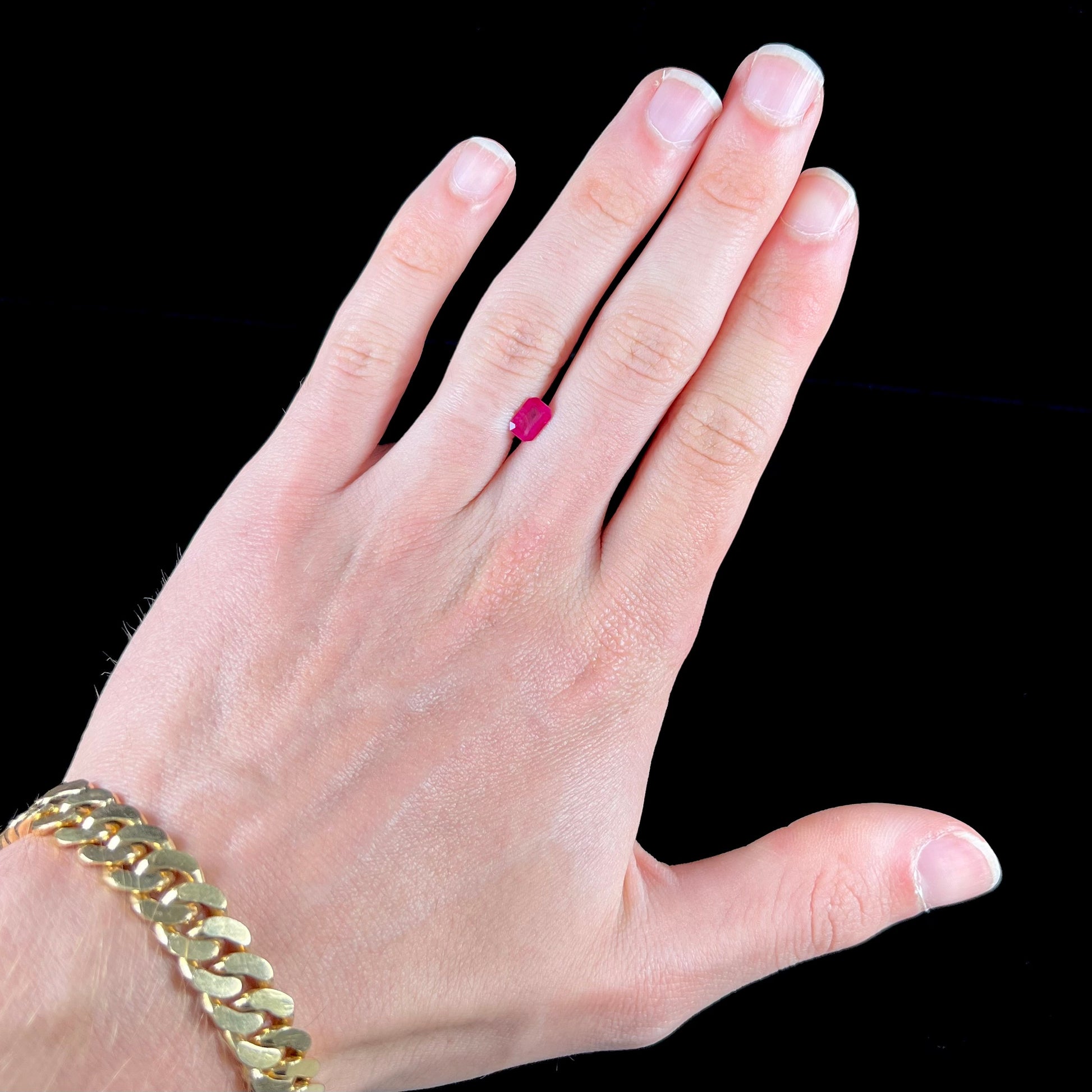 A natural, emerald cut Burma ruby gemstone.  The stone is pinkish red color.