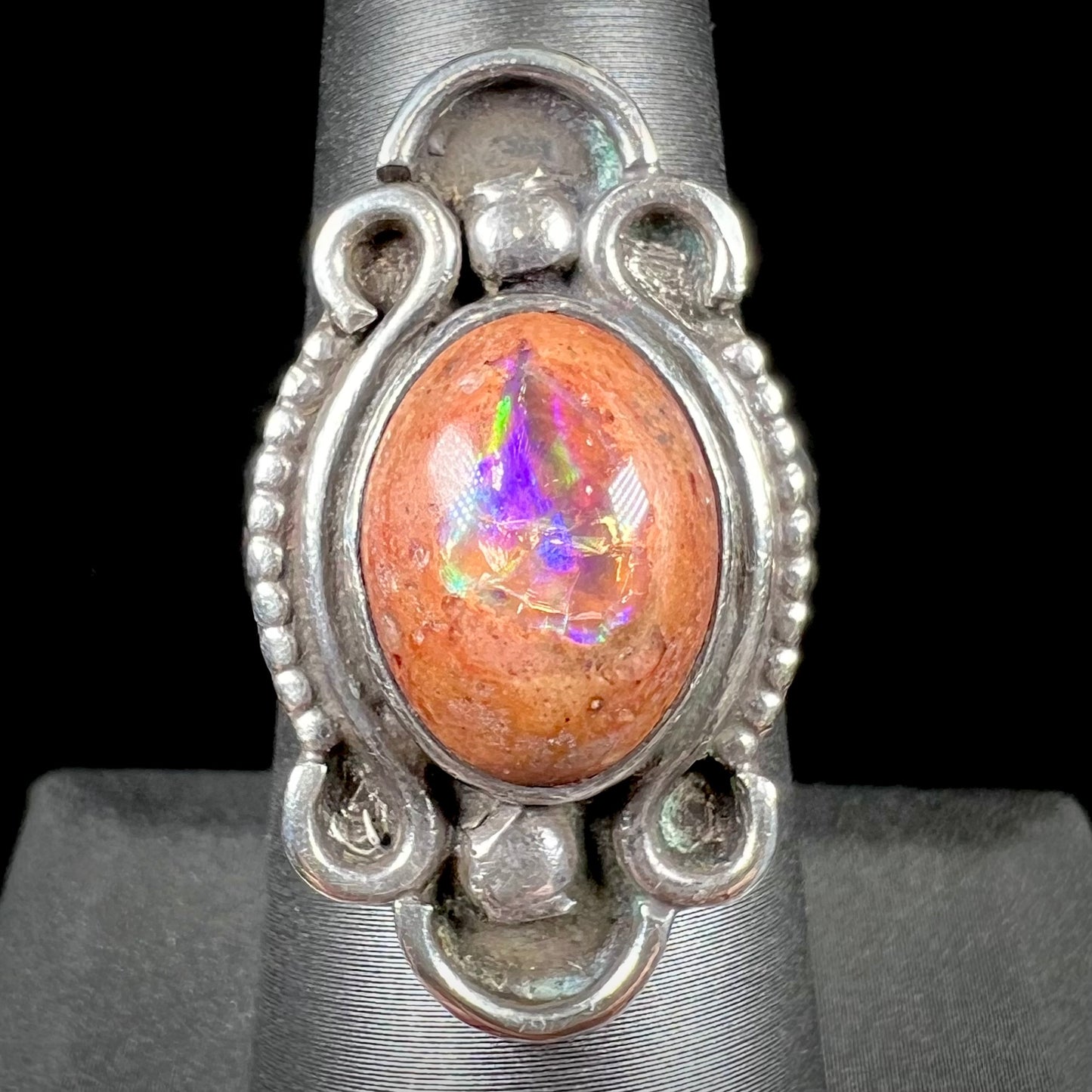A vintage, Navajo style sterling silver ring set with an oval cabochon cut cantera fire opal stone.