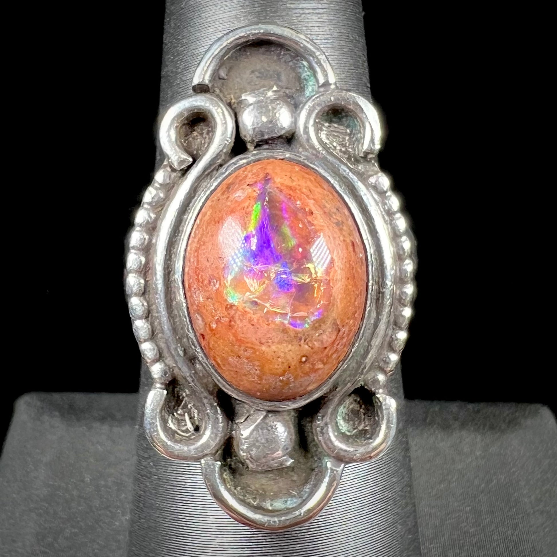 A vintage, Navajo style sterling silver ring set with an oval cabochon cut cantera fire opal stone.