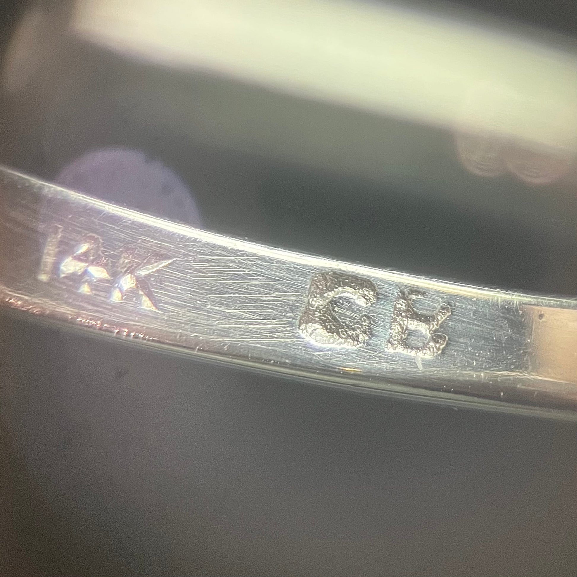 A ladies' 1800's antique white gold diamond ring.  The center stone is an Early American Cut diamond, and the accent stones are Old Mine Cut diamonds.