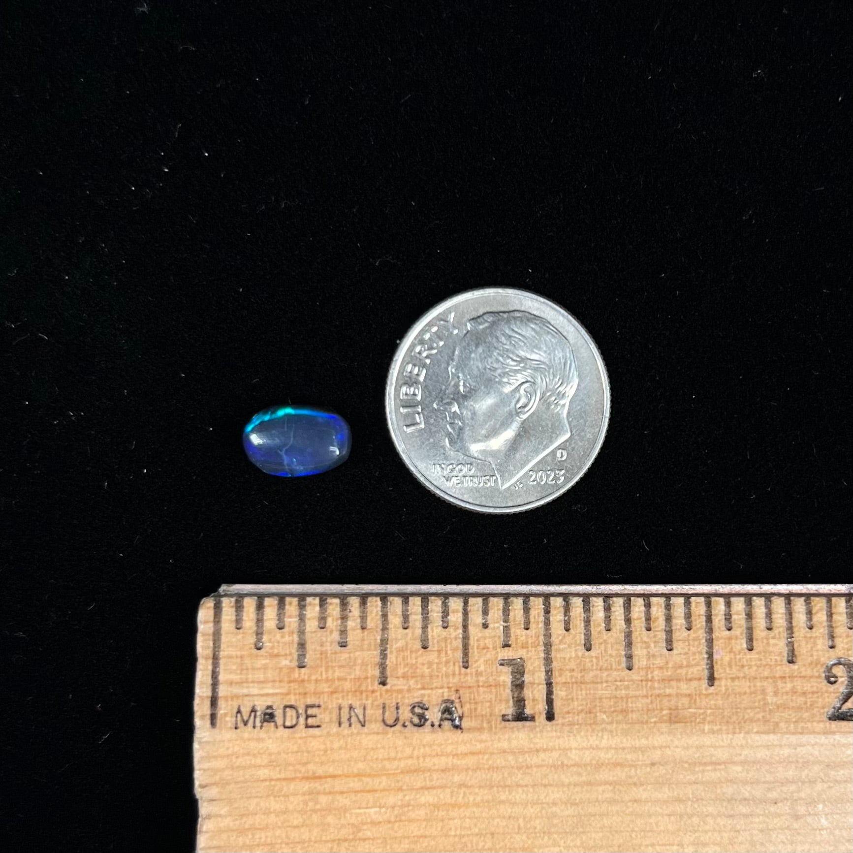 A loose black opal from Lightning Ridge, Australia.  The opal displays a blue cat's eye pattern.