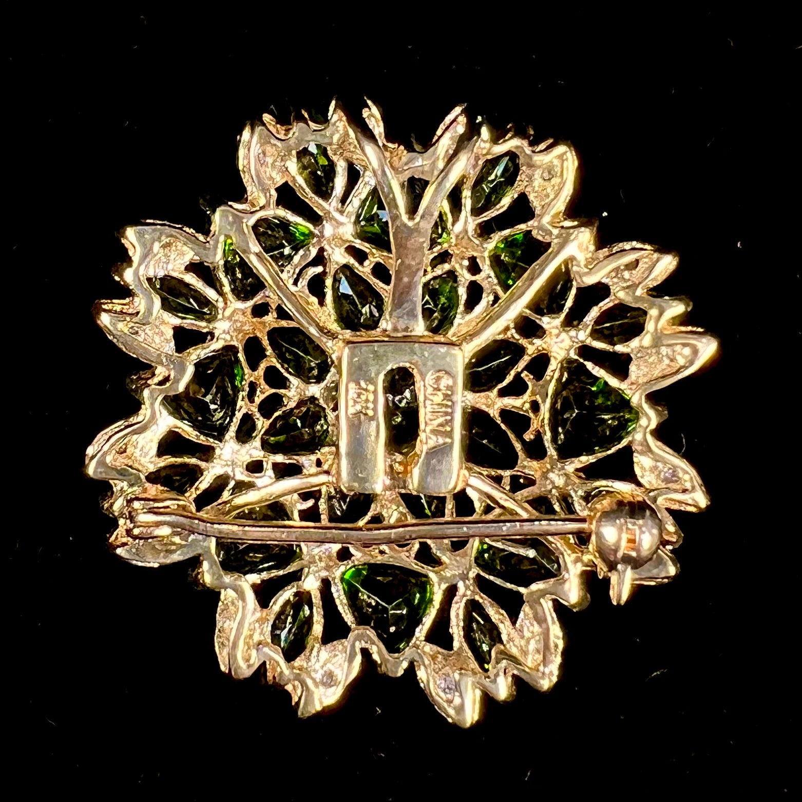 A ladies' pendant set with green chrome diopside stones and diamonds.  The pendant can be worn as a brooch.