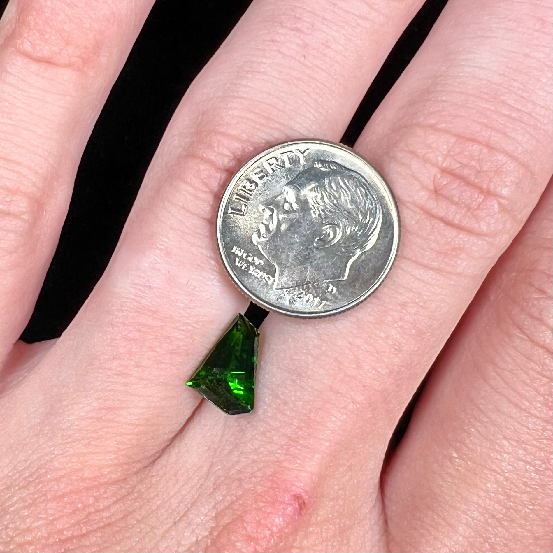 A freeform shield cut chrome diopside gemstone.