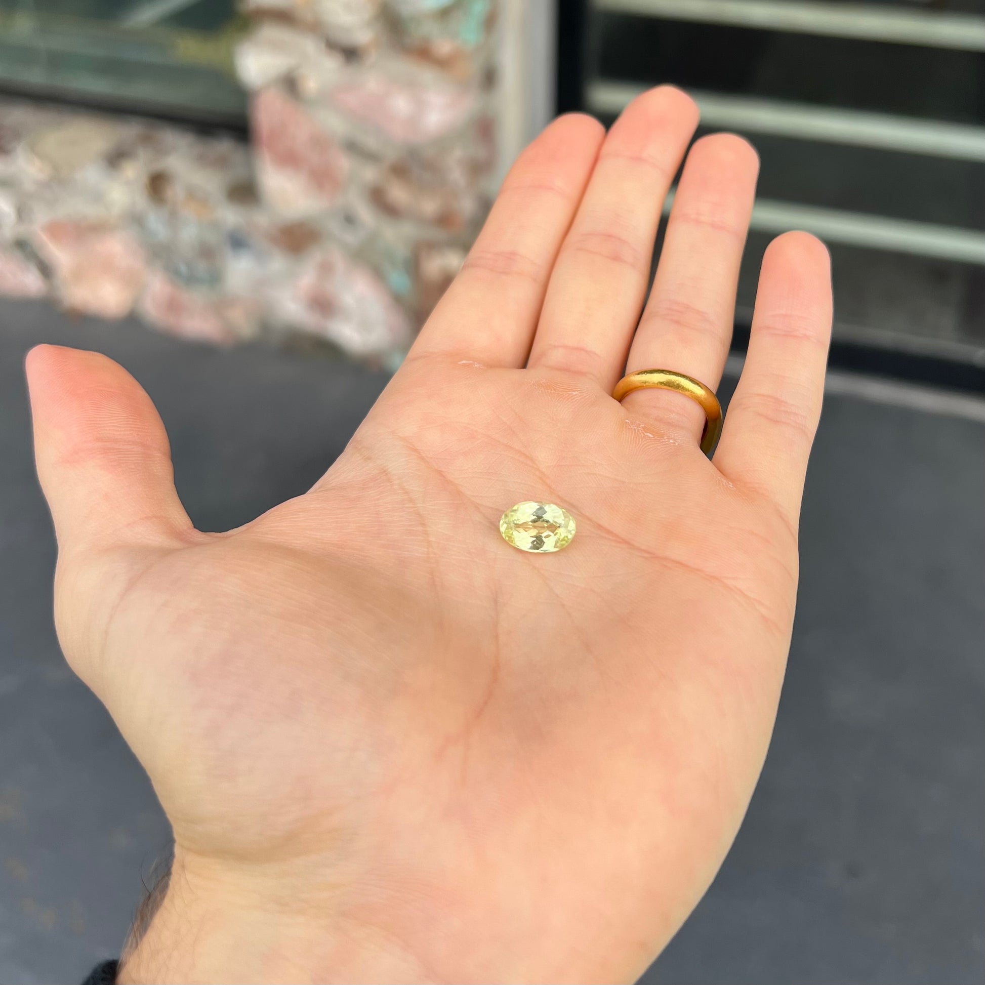 A loose, faceted oval cut chrysoberyl gemstone.  The stone is a greenish yellow color.