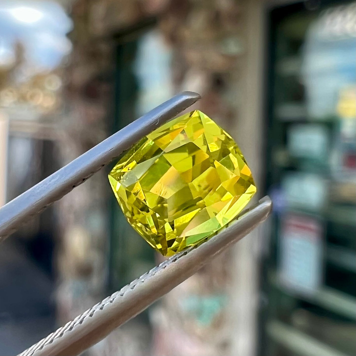 A loose, modified cushion cut greenish yellow chrysoberyl gemstone.