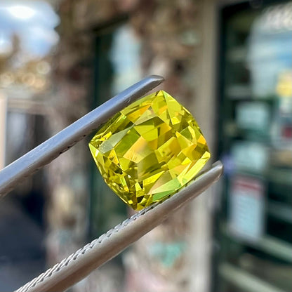 A loose, modified cushion cut greenish yellow chrysoberyl gemstone.