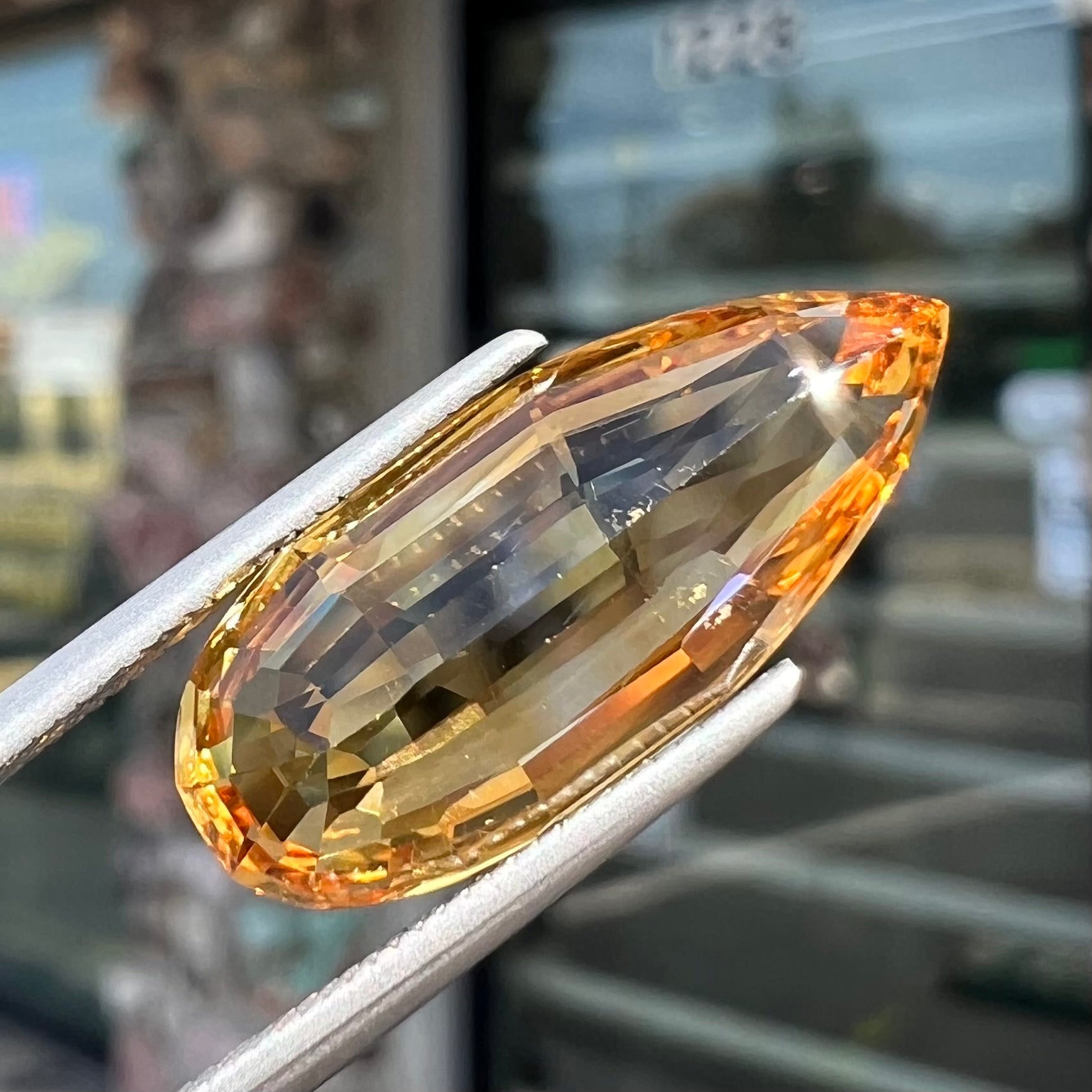 A loose, faceted briolette cut citrine gemstone.