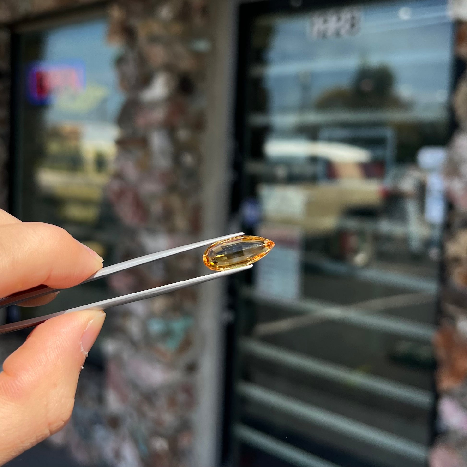 A loose, faceted briolette cut citrine gemstone.