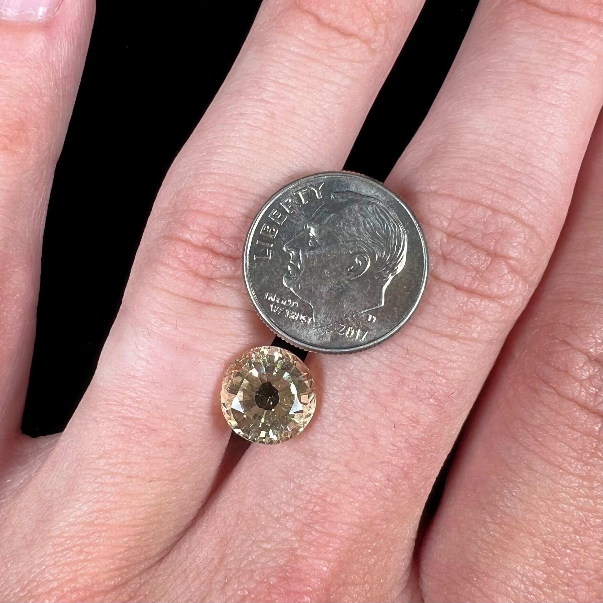 A loose, round brilliant cut citrine gemstone.  The stone is light yellow color.