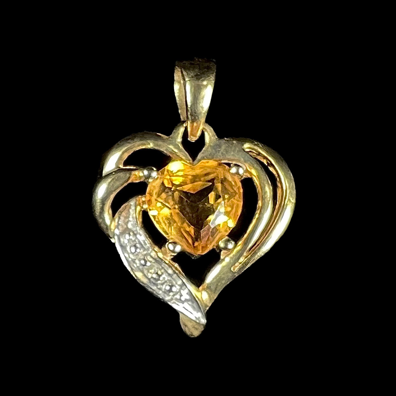 A ladies' yellow gold pendant set with a heart cut citrine stone and a diamond accent.