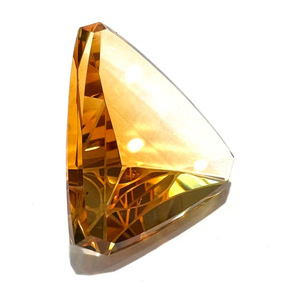 A loose, triangular fantasy cut yellow citrine stone cut by Arthur Lee Anderson.