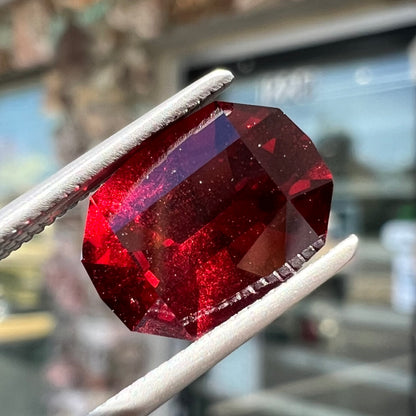 A loose, octagon cut rhodolite garnet gemstone.  The stone is a deep, purplish crimson red color.