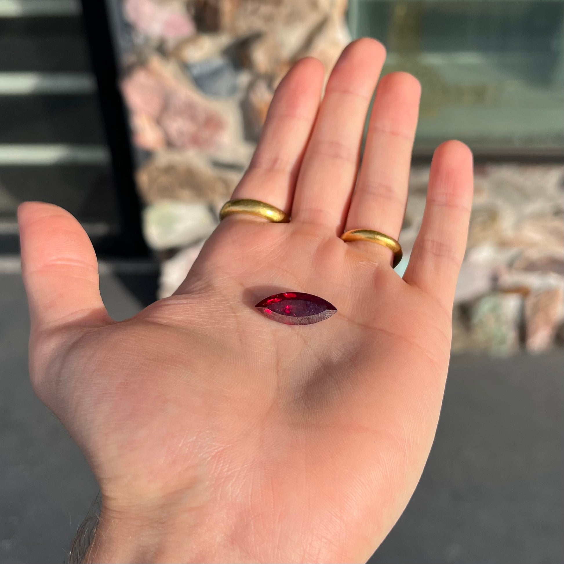 A loose, marquise cut cuprite gemstone.  The stone is a deep, crimson red color.