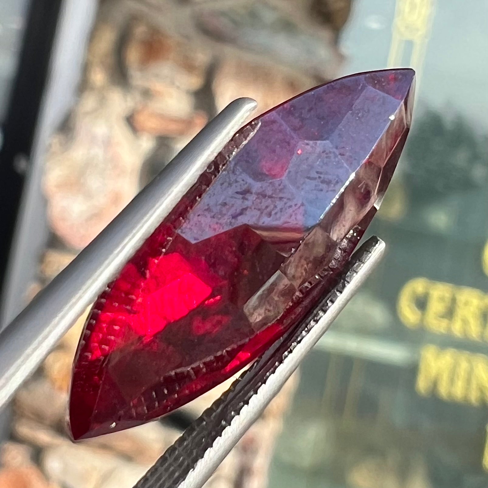 A loose, marquise cut cuprite gemstone.  The stone is a deep, crimson red color.