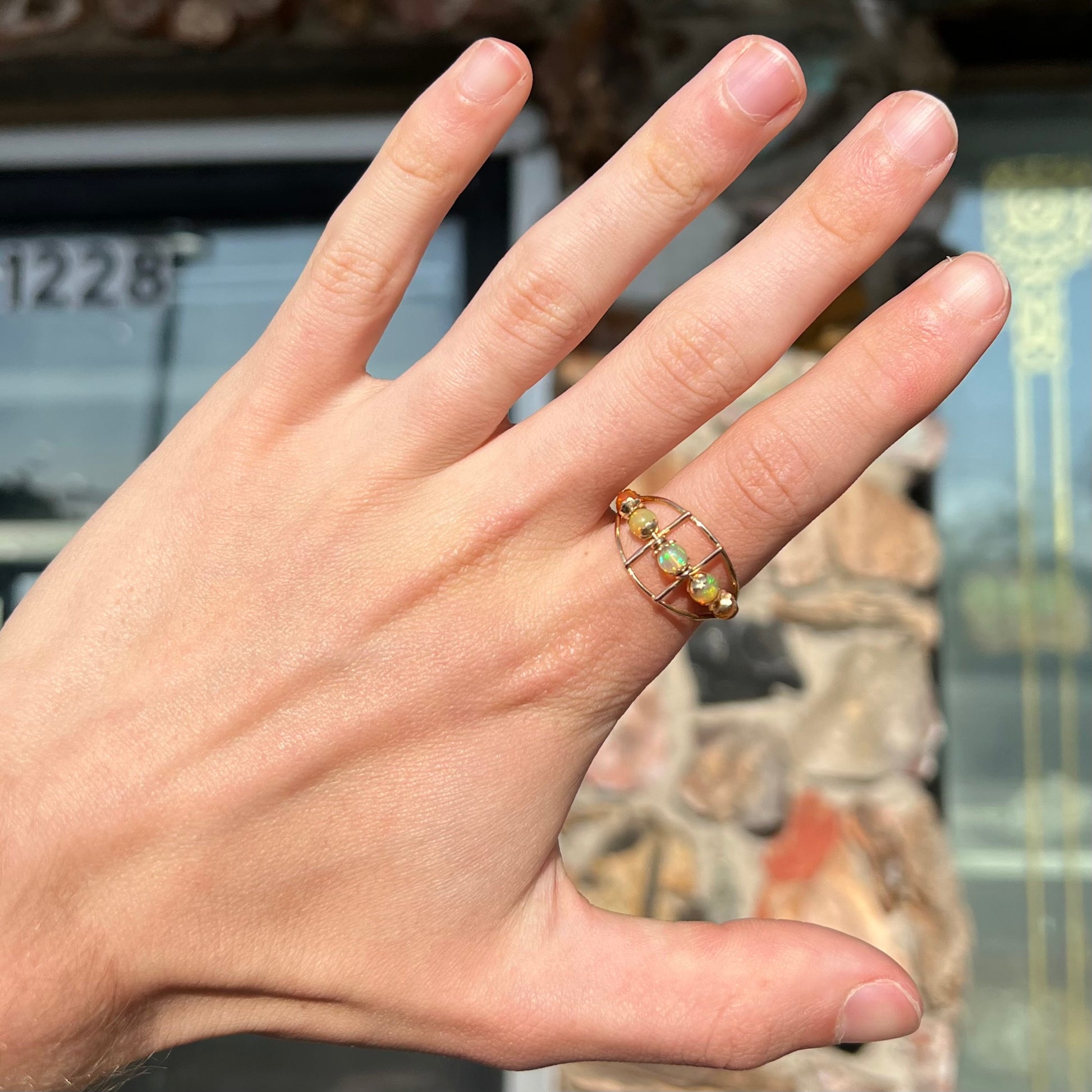 An 18 karat yellow gold ring set with five natural fire opal beads that spin along the ring.
