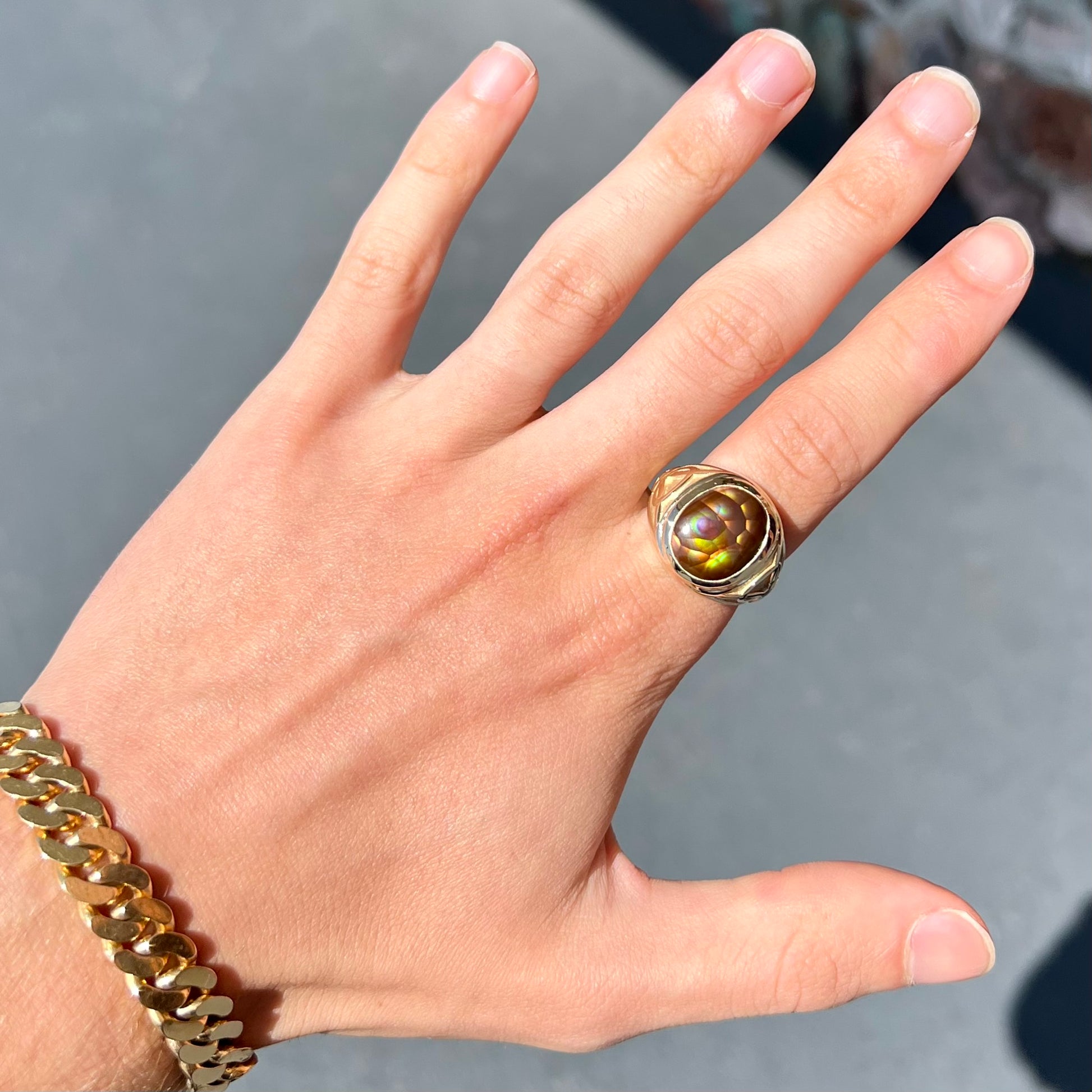 A men's solid yellow gold ring set with a Mexican fire agate stone.  The fire agate has a puple bull's eye pattern.