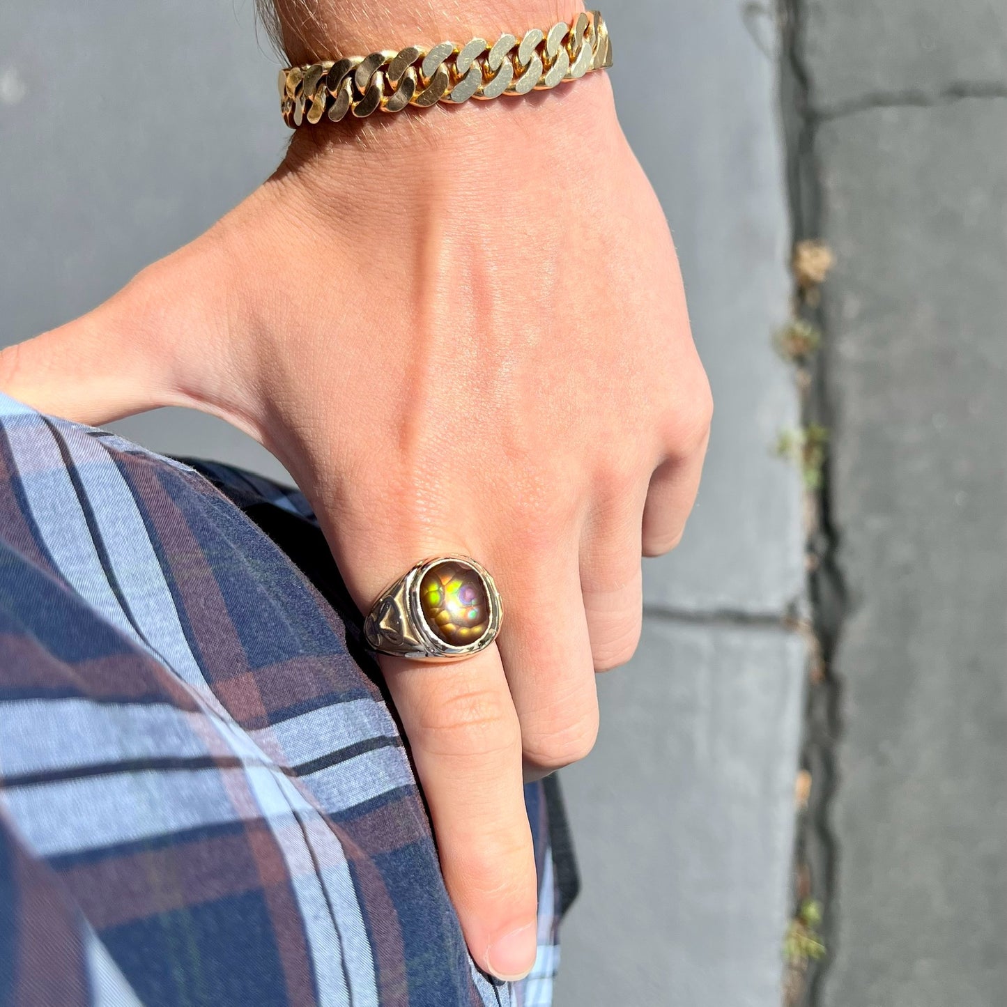 A men's solid yellow gold ring set with a Mexican fire agate stone.  The fire agate has a puple bull's eye pattern.