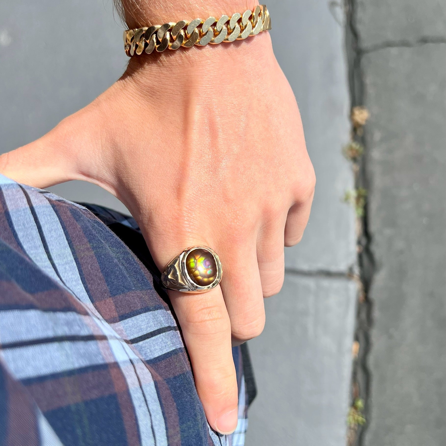 A men's solid yellow gold ring set with a Mexican fire agate stone.  The fire agate has a puple bull's eye pattern.