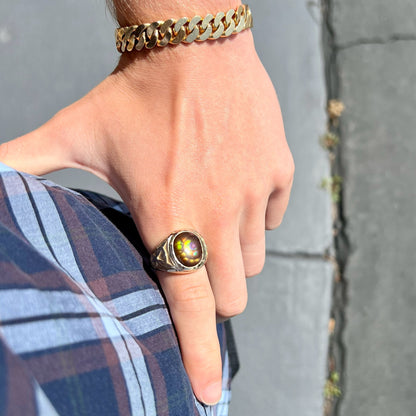 A men's solid yellow gold ring set with a Mexican fire agate stone.  The fire agate has a puple bull's eye pattern.