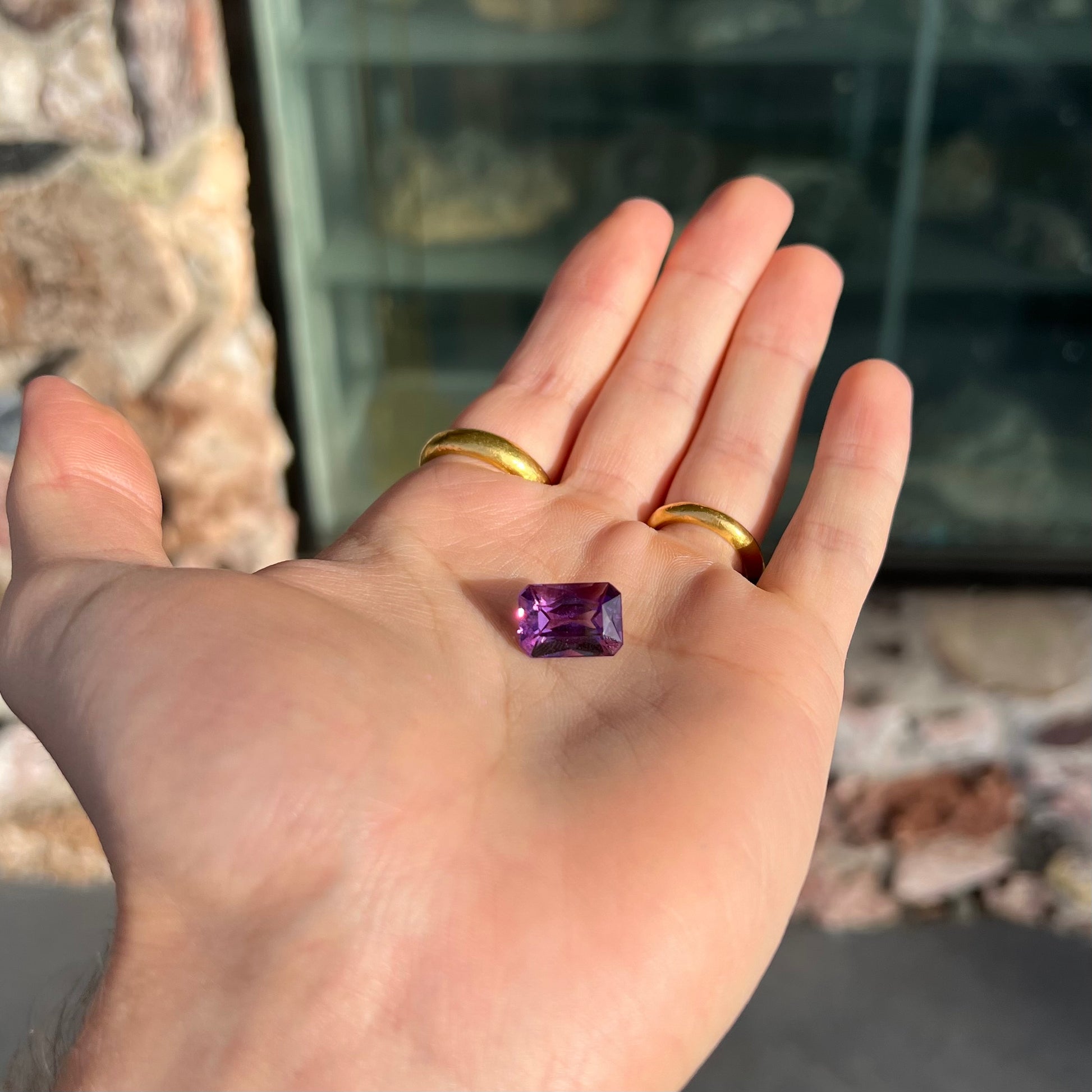 A loose, modified radiant cut amethyst stone.