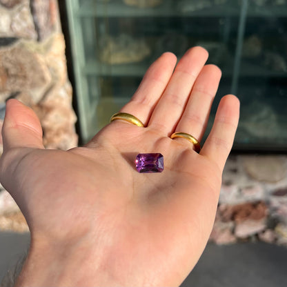 A loose, modified radiant cut amethyst stone.