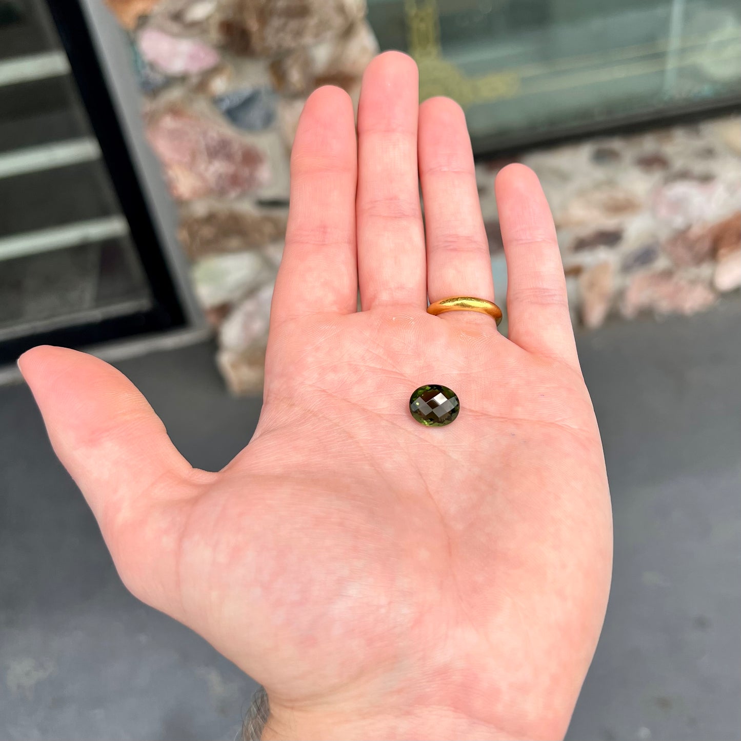 A loose, oval cut natural moldavite gemstone.  The stone weighs 3.85 carats.