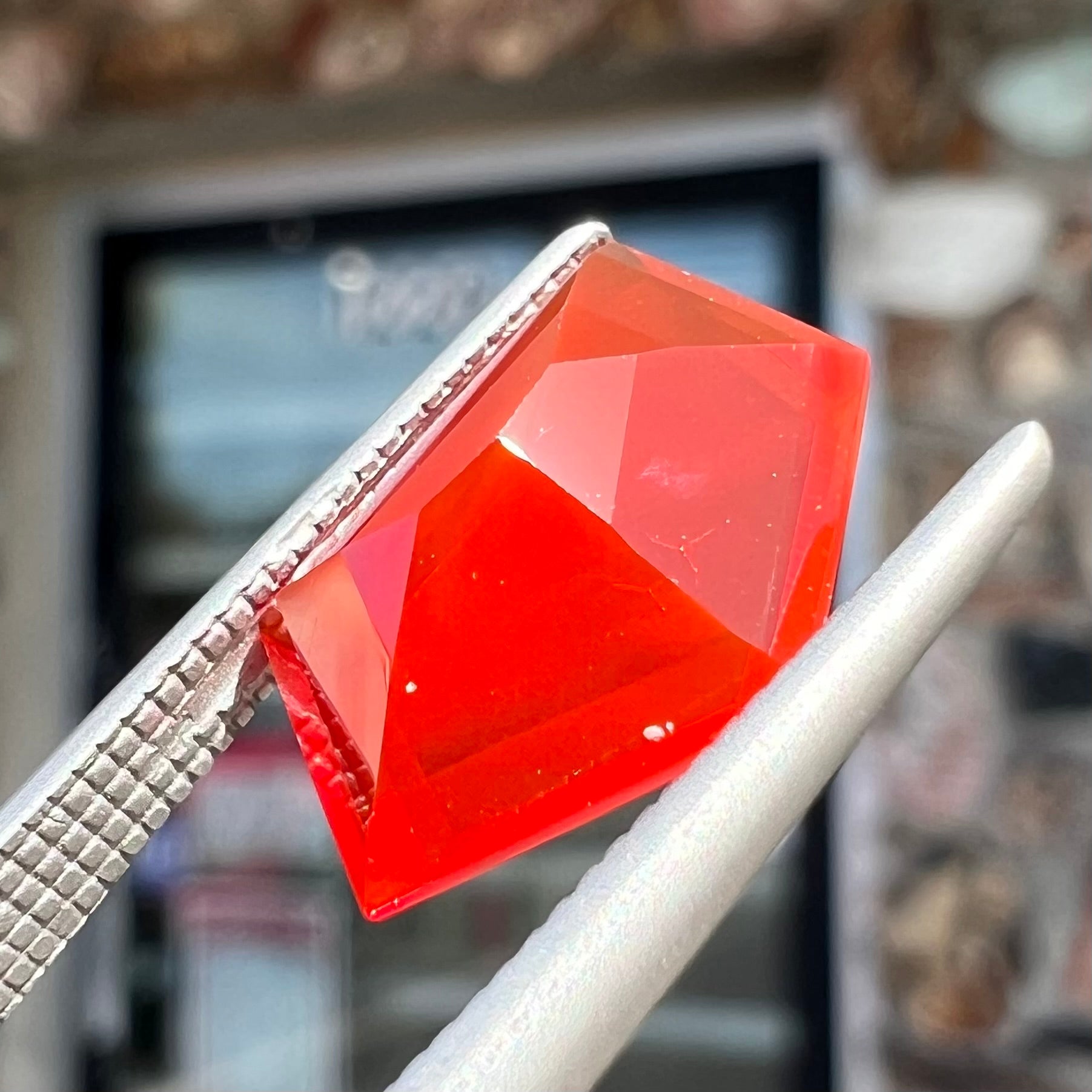 A loose, faceted freeform cut Mexican fire opal gemstone.  The stone is a cherry red color.