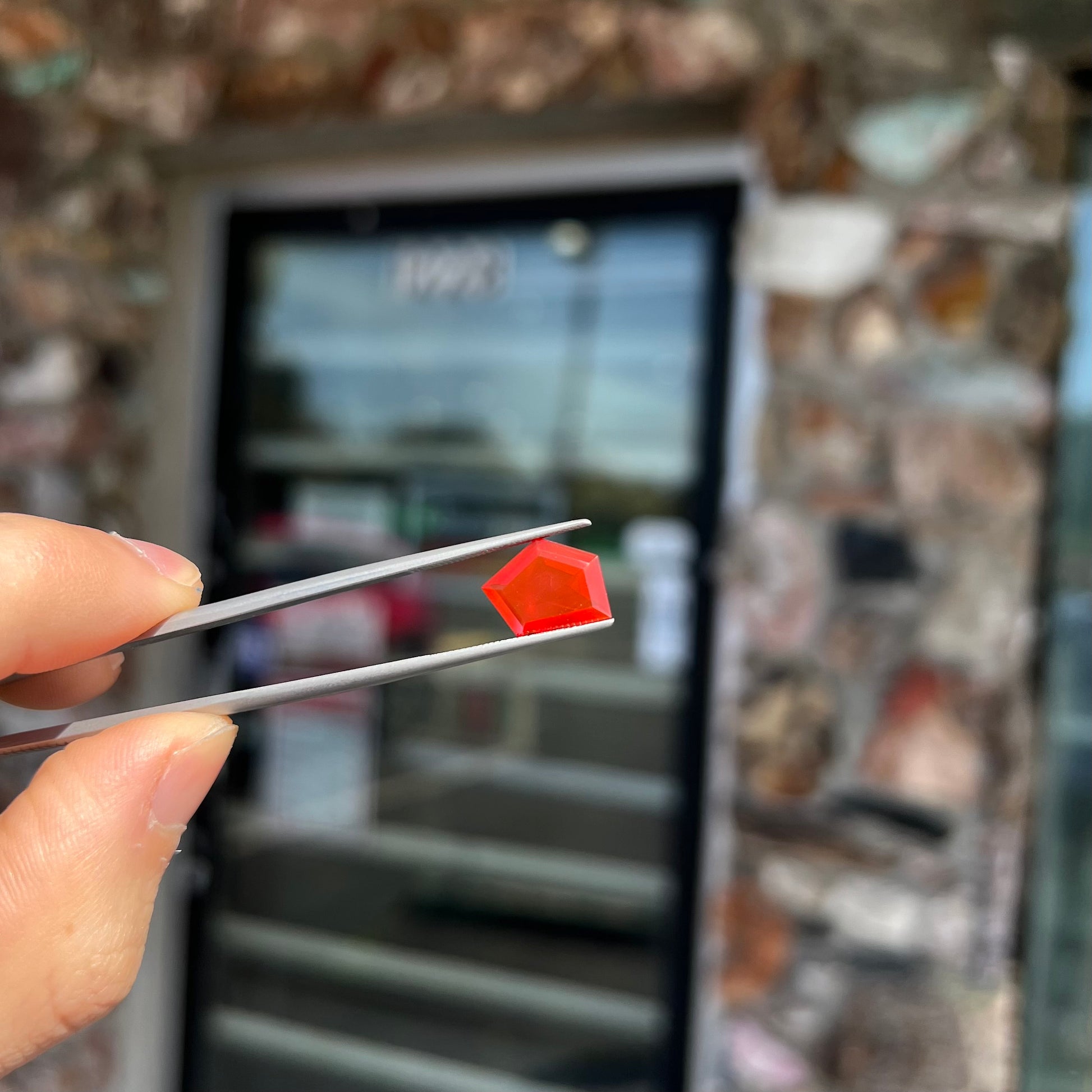 A loose, faceted freeform cut Mexican fire opal gemstone.  The stone is a cherry red color.