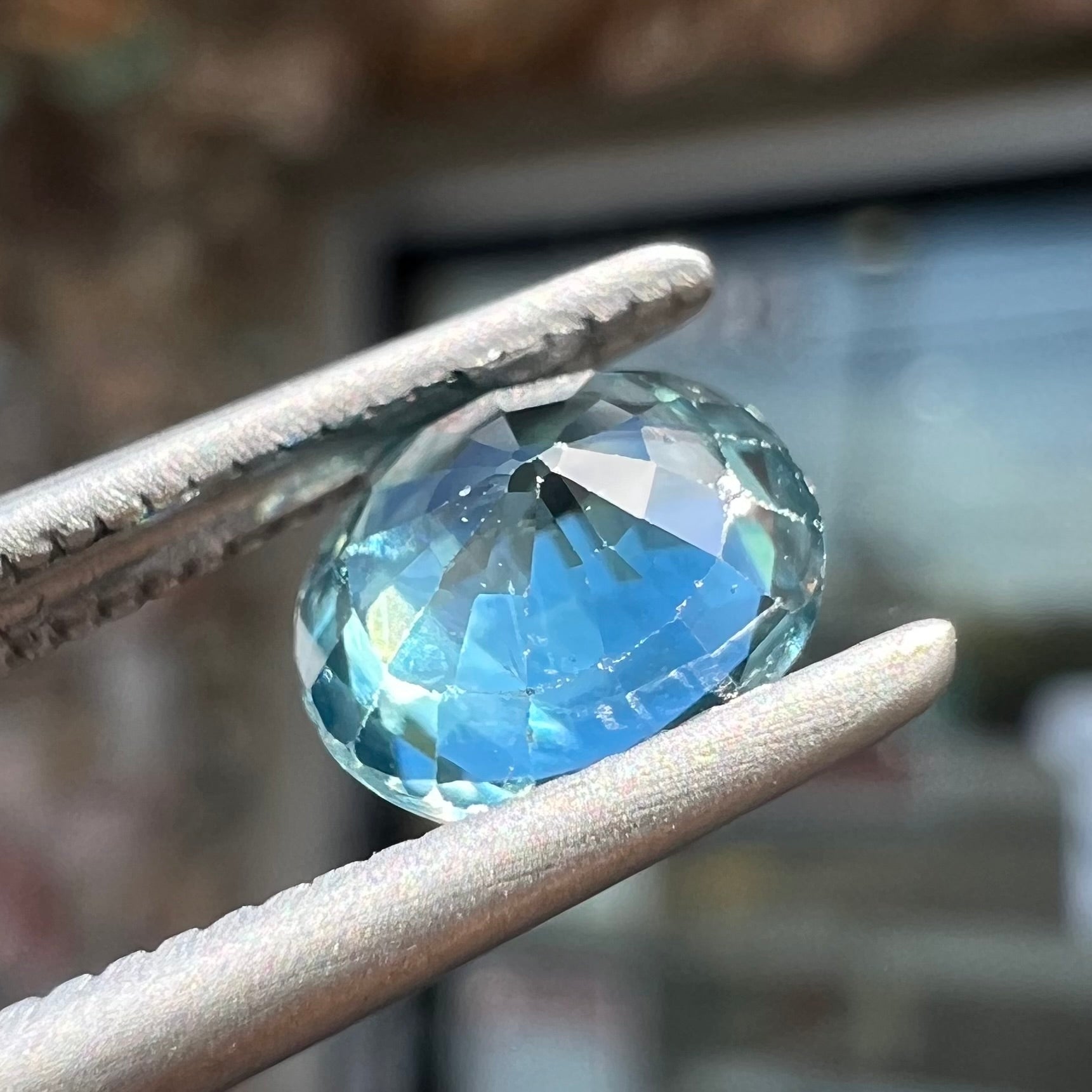 A loose, faceted oval cut blue zircon gemstone.