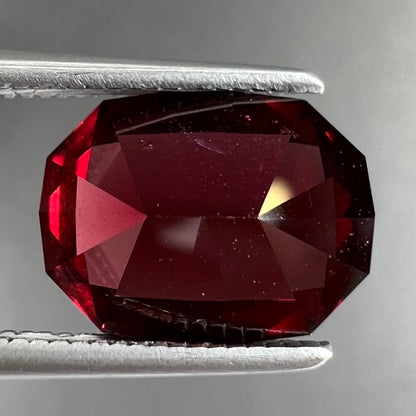 A loose, octagon cut rhodolite garnet gemstone.  The stone is a deep, purplish crimson red color.
