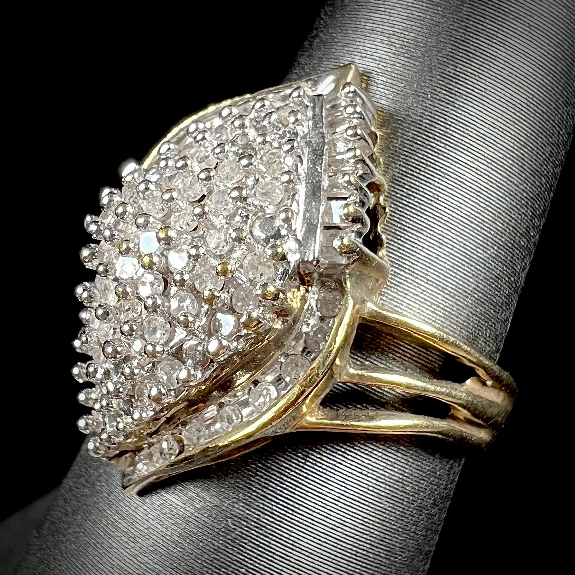 A ladies' yellow gold and diamond cluster ring.  The diamonds are round and baguette shaped, and the ring is navette shaped.