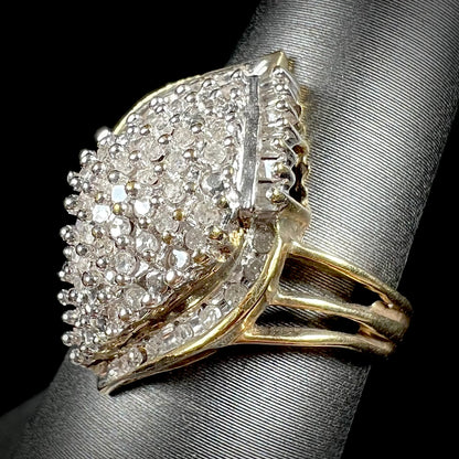 A ladies' yellow gold and diamond cluster ring.  The diamonds are round and baguette shaped, and the ring is navette shaped.