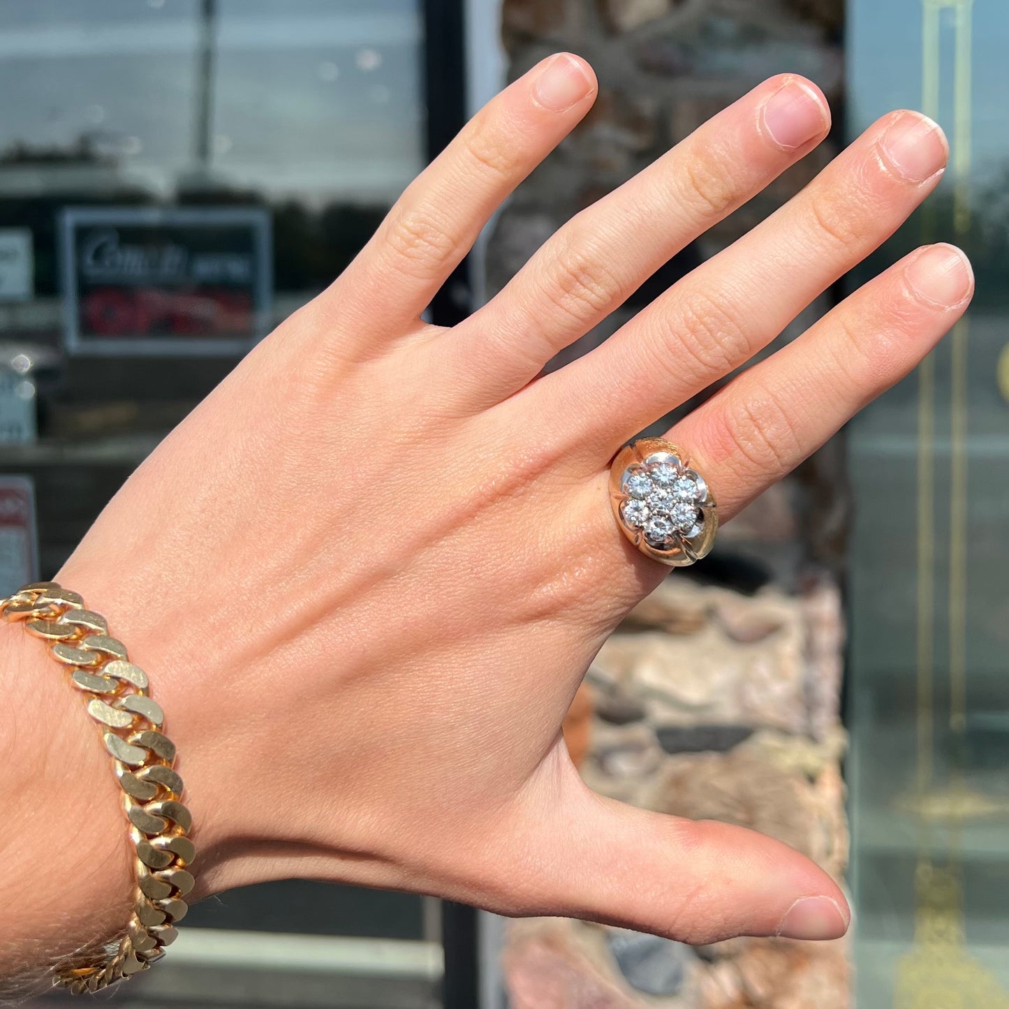 A men's textured yellow gold ring set with a cluster of seven round brilliant cut natural diamonds.