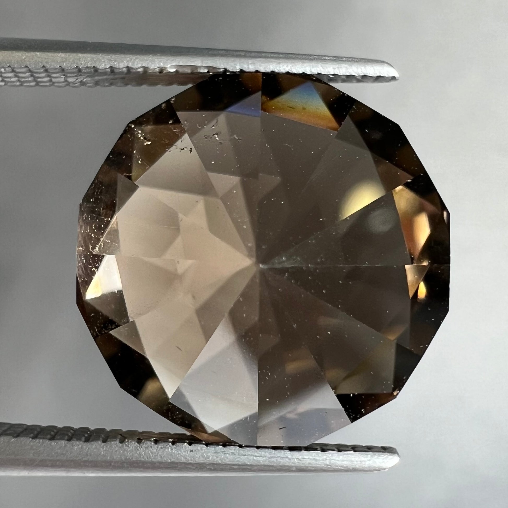 A loose, modified brilliant Portuguese cut smoky quartz gemstone.
