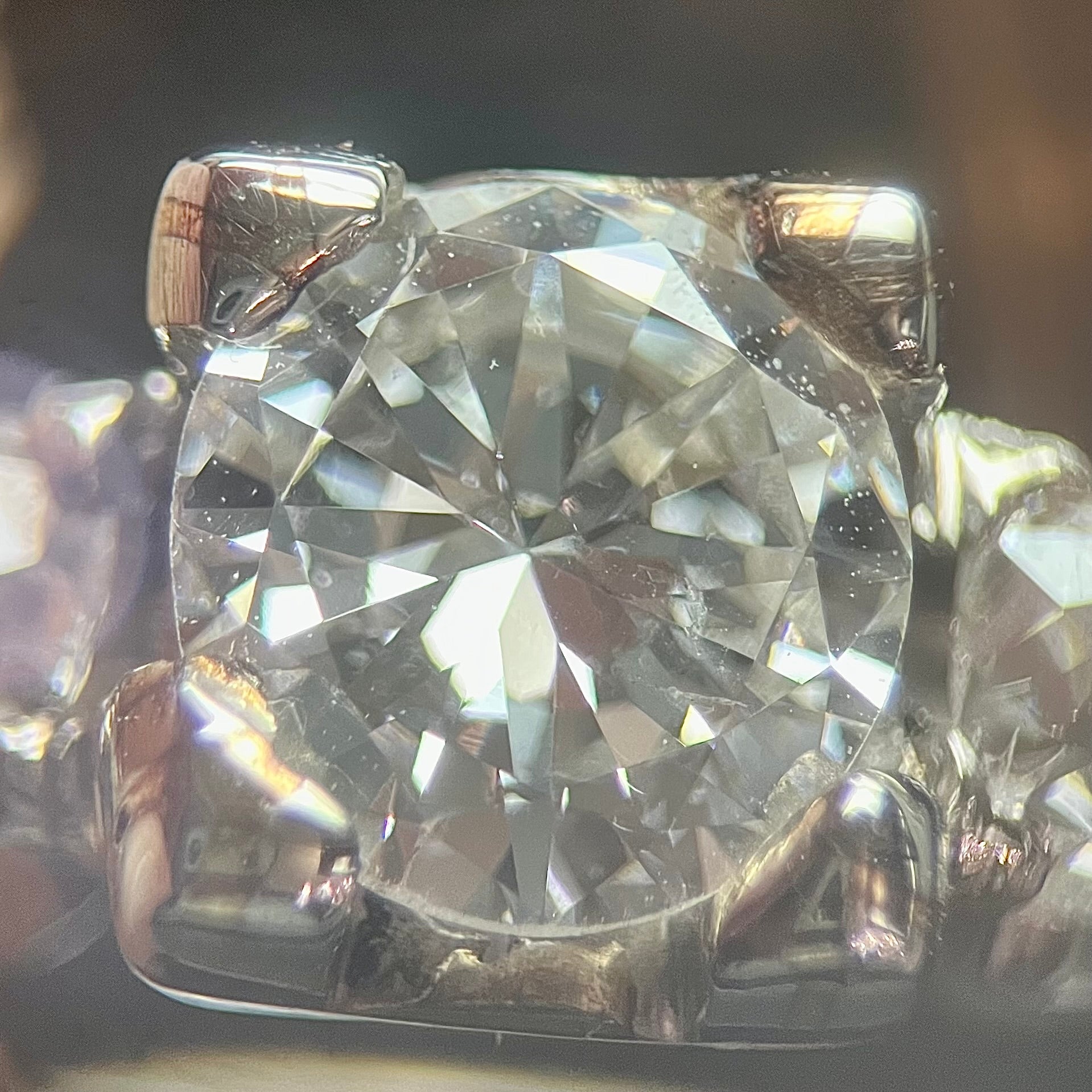 A ladies' 1800's antique white gold diamond ring.  The center stone is an Early American Cut diamond, and the accent stones are Old Mine Cut diamonds.