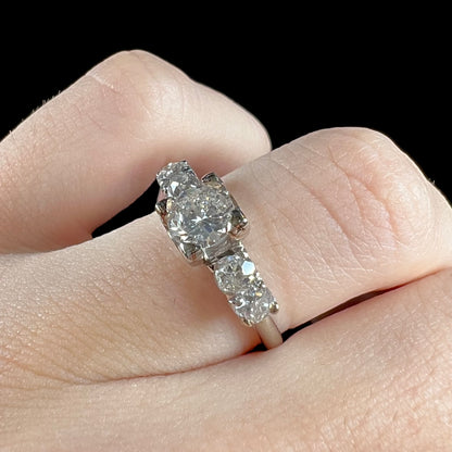 A ladies' 1800's antique white gold diamond ring.  The center stone is an Early American Cut diamond, and the accent stones are Old Mine Cut diamonds.