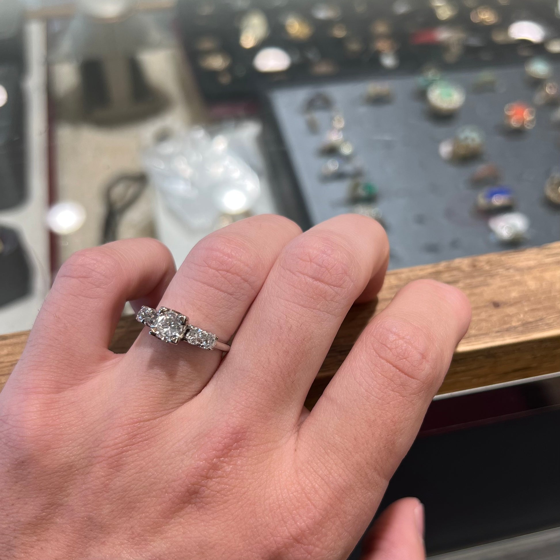 A ladies' 1800's antique white gold diamond ring.  The center stone is an Early American Cut diamond, and the accent stones are Old Mine Cut diamonds.