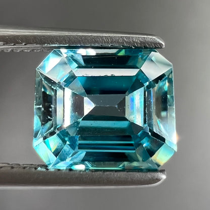A loose, emerald cut blue zircon gemstone.
