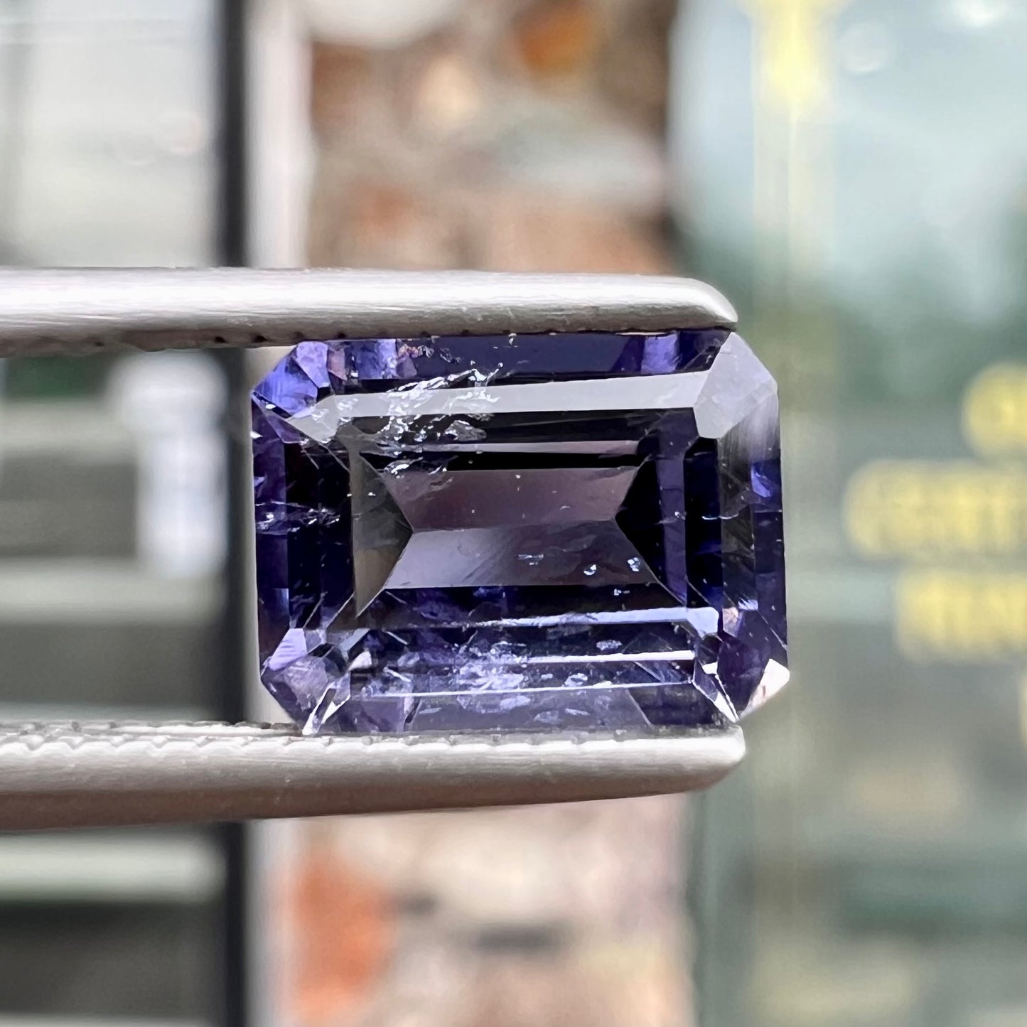 A loose, emerald cut blue iolite gemstone.