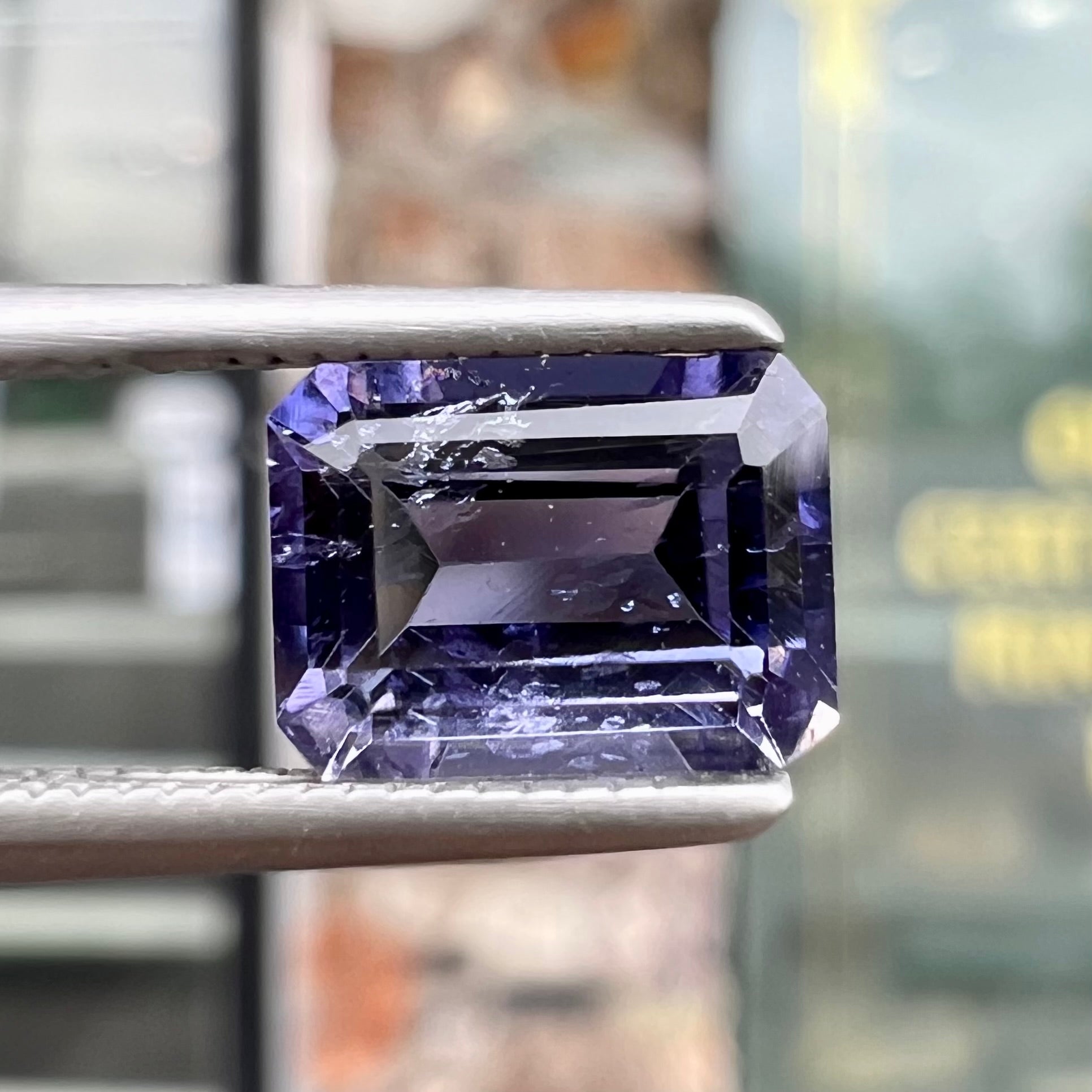 A loose, emerald cut blue iolite gemstone.